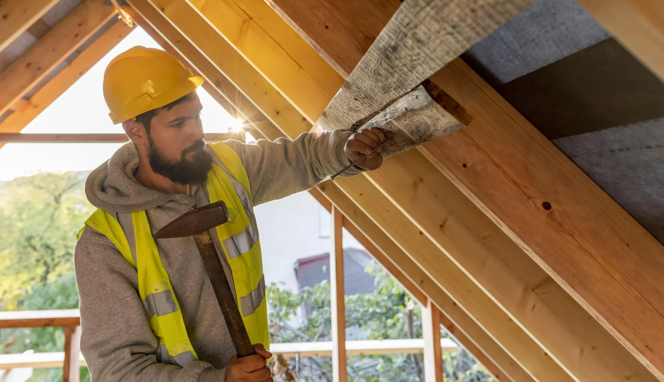Pose d’un isolant sous toiture pour une isolation des combles aménageables. Un artisan installe une couche d’isolation pour optimiser l’efficacité thermique de la maison.