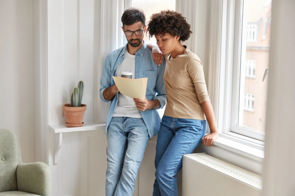 Un couple consulte une facture énergétique à la maison avec un air soucieux.